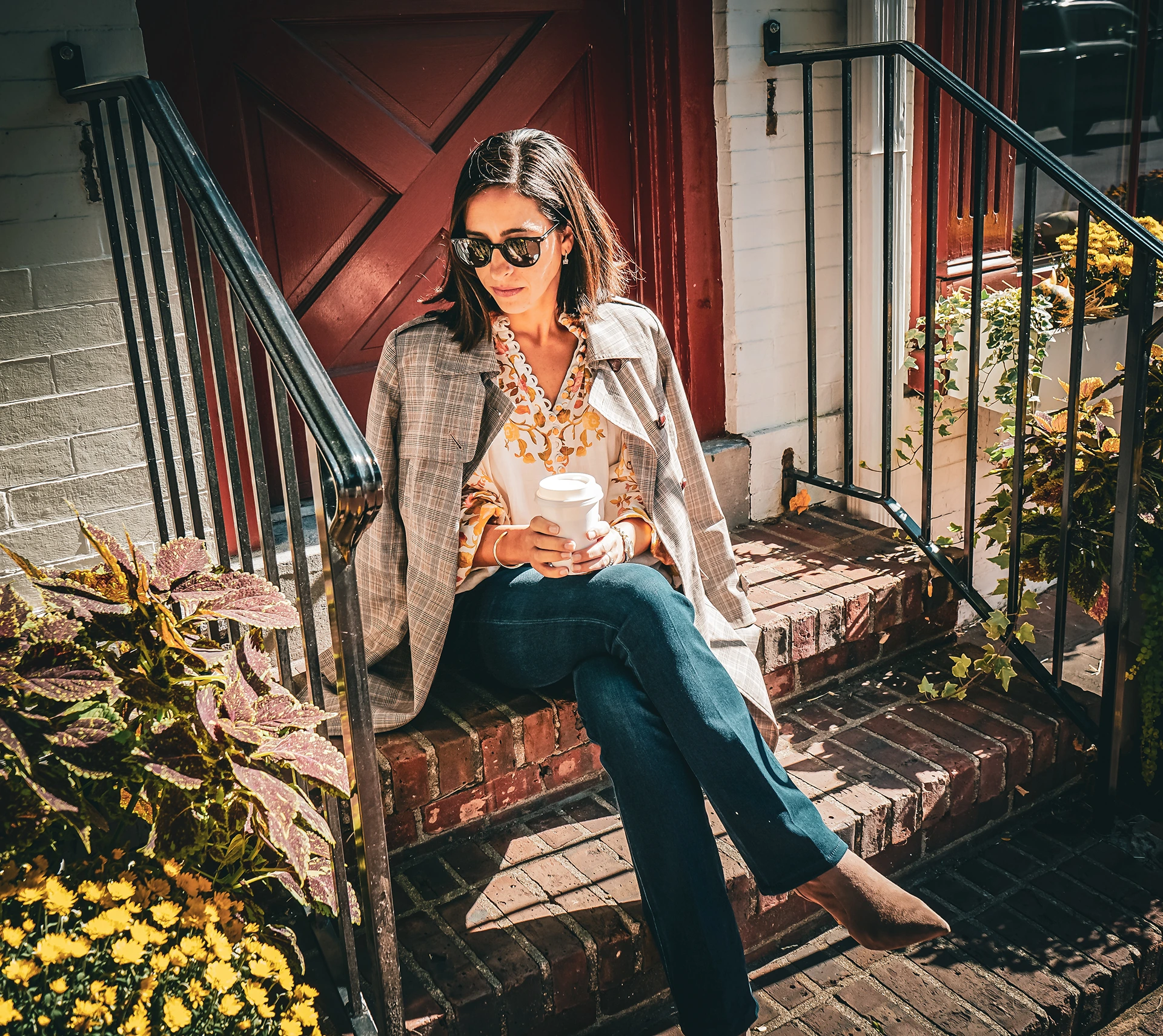 a woman sitting on steps holding a cup of coffee